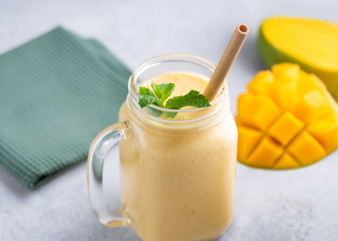 Mango smoothie in a handled glass jar with mint, a straw, sliced mango, and a folded green napkin. Photo 4 &mdash; Vertical Mango Smoothie with Napkin Photo Title: Refreshing Mango Smoothie Recipe Pinterest Title: Refreshing Mango Smoothie with Frozen Mango Pinterest Description: Cool down with an easy Mango Smoothie made with frozen mango, milk, protein powder, and ice. It&rsquo;s creamy, fruity, full of tropical flavor, and ideal for breakfast, after a workout, or as an afternoon pick-me-up. Alt Text: Creamy mango smoothie topped with mint in a glass mug beside sliced mango and a green napkin. Photo 5 &mdash; Mango Smoothie with Fruit at Base Photo Title: Homemade Mango Smoothie with Protein Pinterest Title: Homemade Mango Smoothie with Protein Powder Pinterest Description: This homemade Mango Smoothie with protein powder is a simple and refreshing way to start the day. Frozen mango creates a naturally creamy texture, while vanilla protein powder makes it a more satisfying breakfast or snack. Alt Text: Mango smoothie in a mason jar mug with fresh mint, a straw, and sliced mango arranged nearby. Photo 6 &mdash; Close-Up Mango Smoothie Photo Title: Thick and Creamy Mango Smoothie Pinterest Title: Thick and Creamy Mango Smoothie Recipe Pinterest Description: Make a thick and creamy Mango Smoothie with only four simple ingredients. Frozen mango, milk, vanilla protein powder, and ice create a refreshing tropical smoothie that&rsquo;s easy to customize and ready in minutes. Alt Text: Close-up of a creamy mango smoothie in a glass mug topped with mint and served with fresh mango. For the two similar upright photos, I varied the wording enough that you can use both without the titles and Pinterest descriptions feeling repetitive.