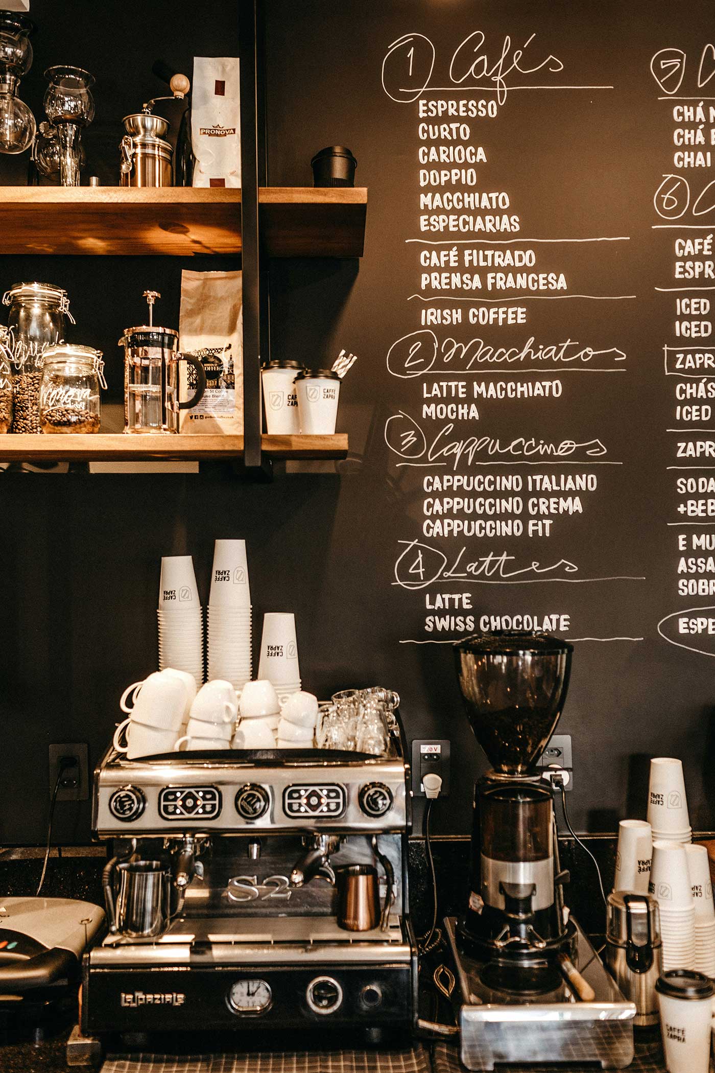 Coffee shop counter with espresso machine and menu board, illustrating skipping the drive-thru to add extra walking.