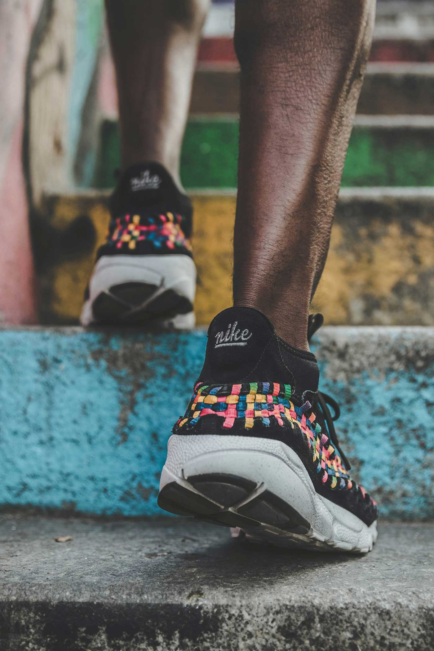 Person walking up colorful outdoor steps wearing sneakers, representing simple tips to walk more throughout the day.