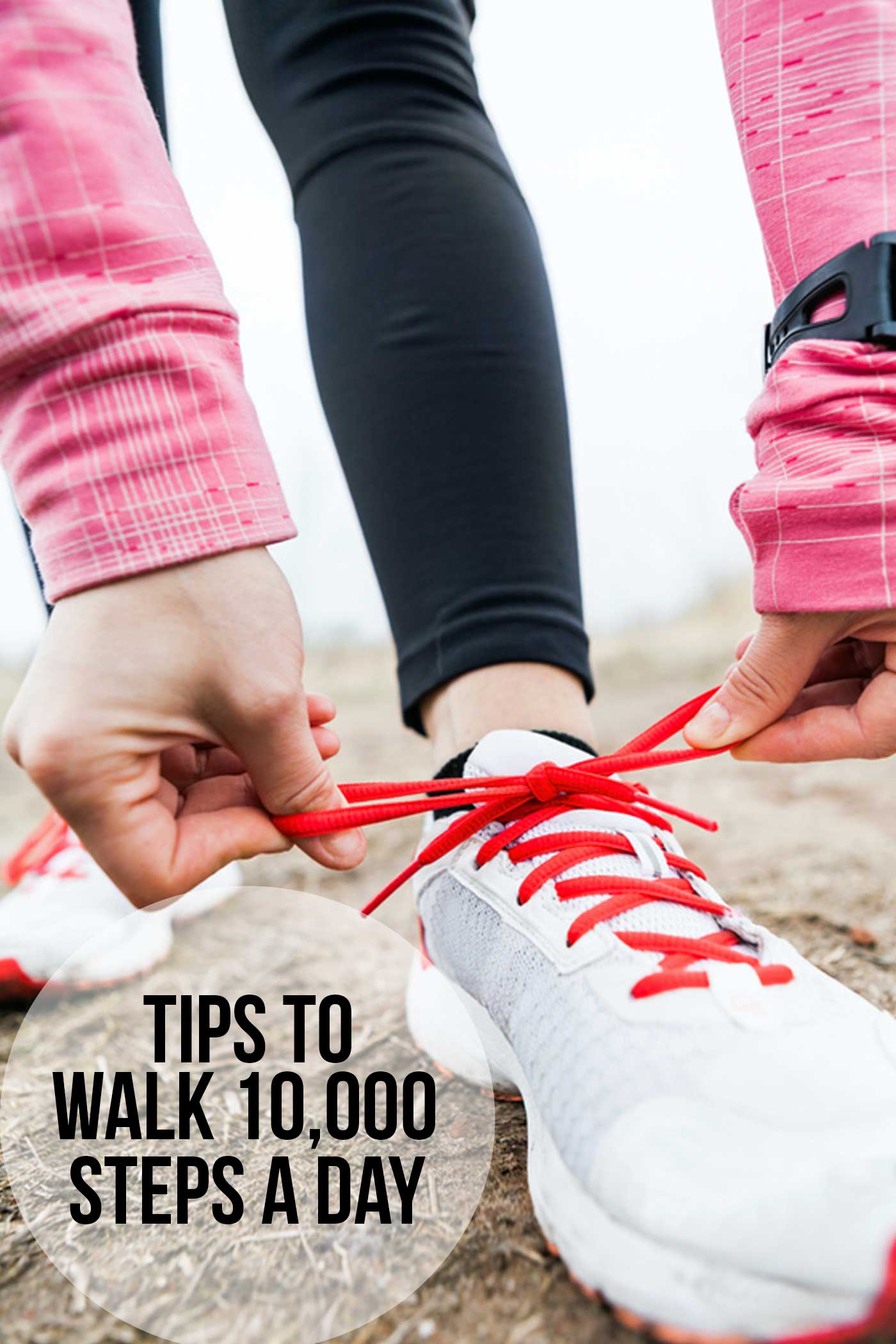 Person tying running shoes outdoors, symbolizing walking 10,000 steps a day as part of a healthy routine.