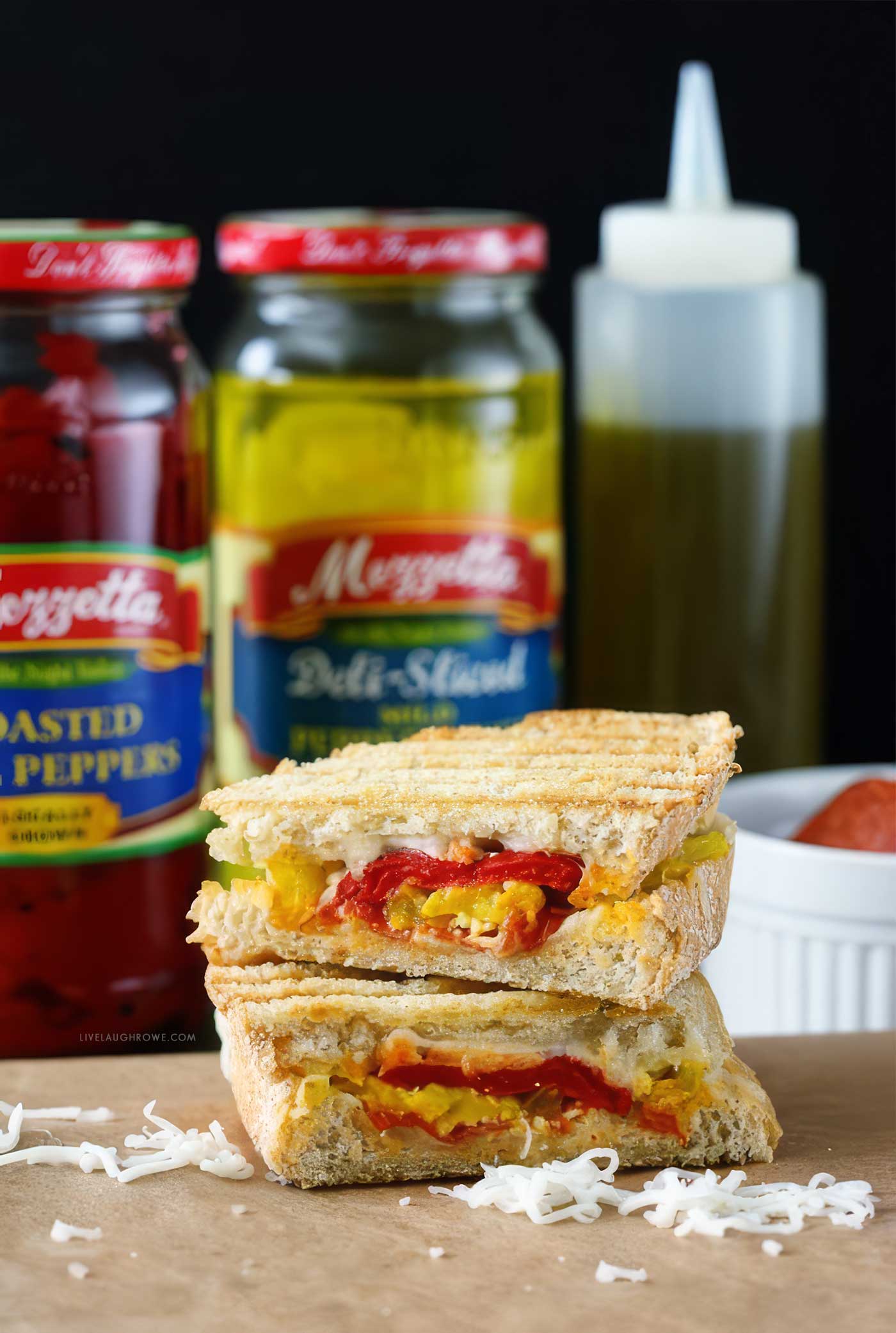 Grilled pizza panini filled with mozzarella cheese, pepperoni, roasted red peppers, and mild pepper rings on sourdough bread.