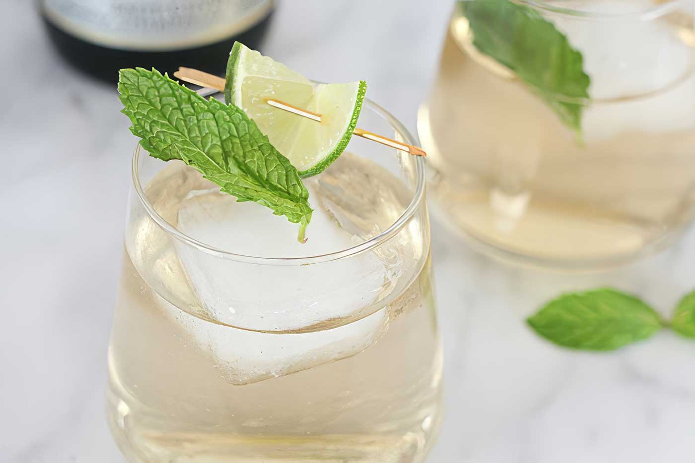 Hugo Spritz with ice, mint, lime, and sparkling wine served in a glass.