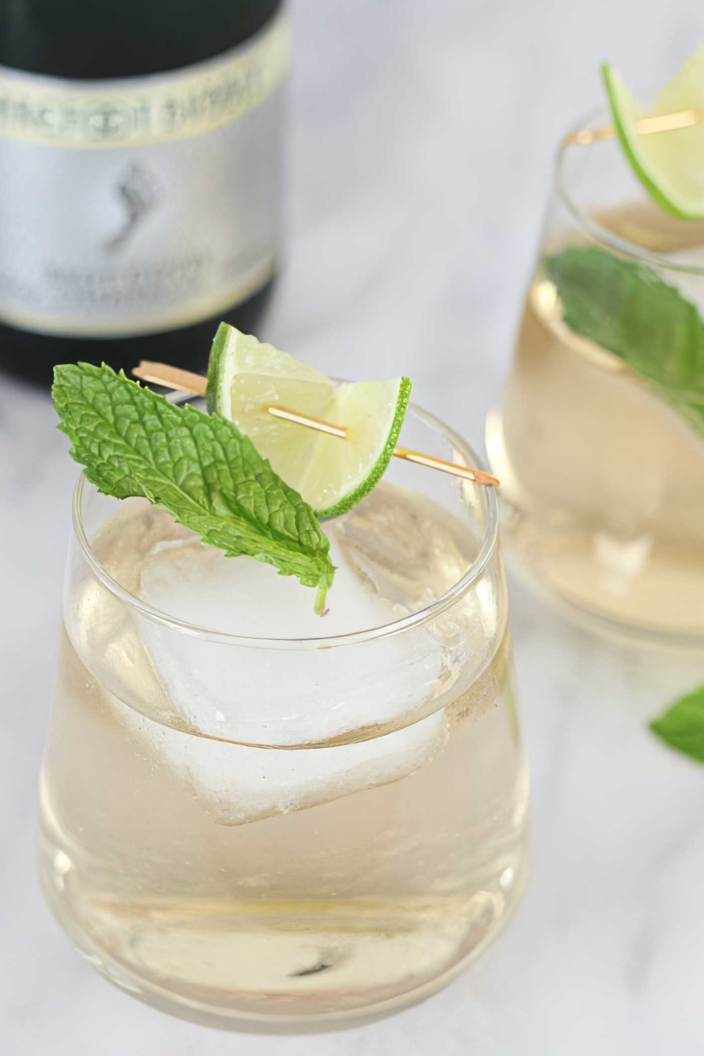 cocktail with elderflower, fresh mint, lime, ice, and sparkling wine.