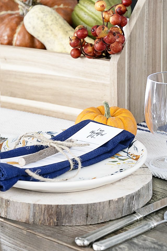 Blogger of livelaughrowe.com shares this simple fall tablescape with rustic flare and offers a free printable bookmark to use at each place setting.