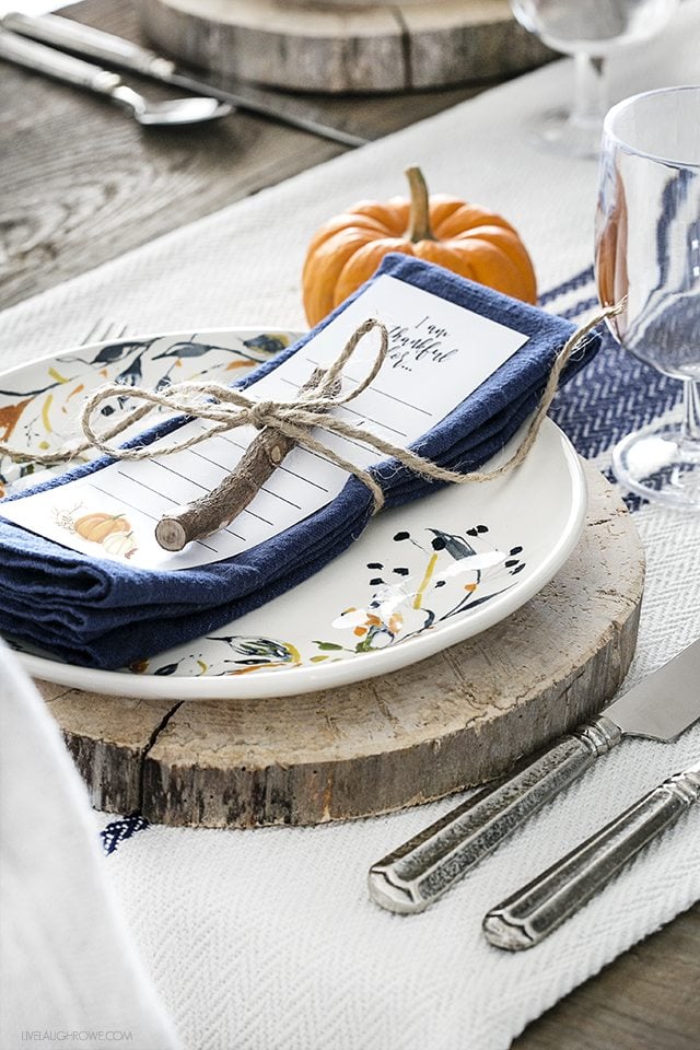 Blogger of livelaughrowe.com shares this simple fall tablescape with rustic flare and offers a free printable bookmark to use at each place setting.