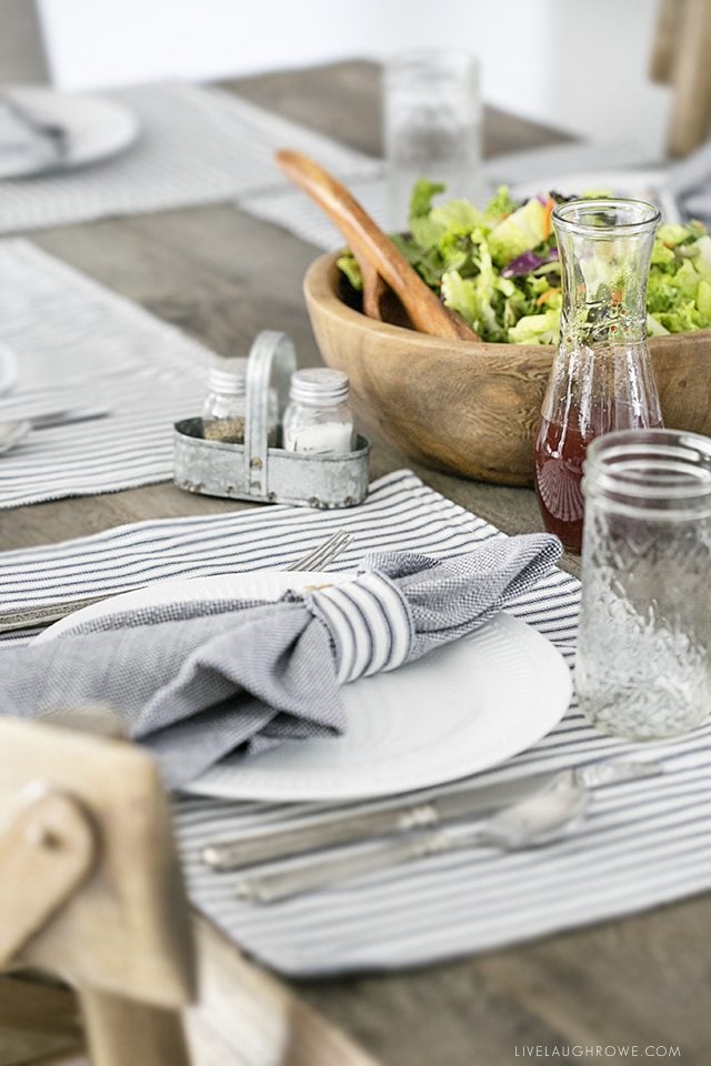 Beautiful farmhouse inspired tablescape using linens with blue ticking stripes. Simple, yet elegant in it's own way. livelaughrowe.com