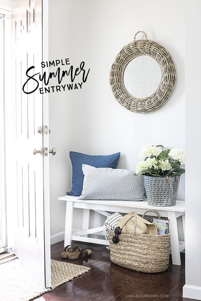 A simple summer entryway with shades of blue and seasonal flowers create a warm and welcoming space. livelaughrowe.com