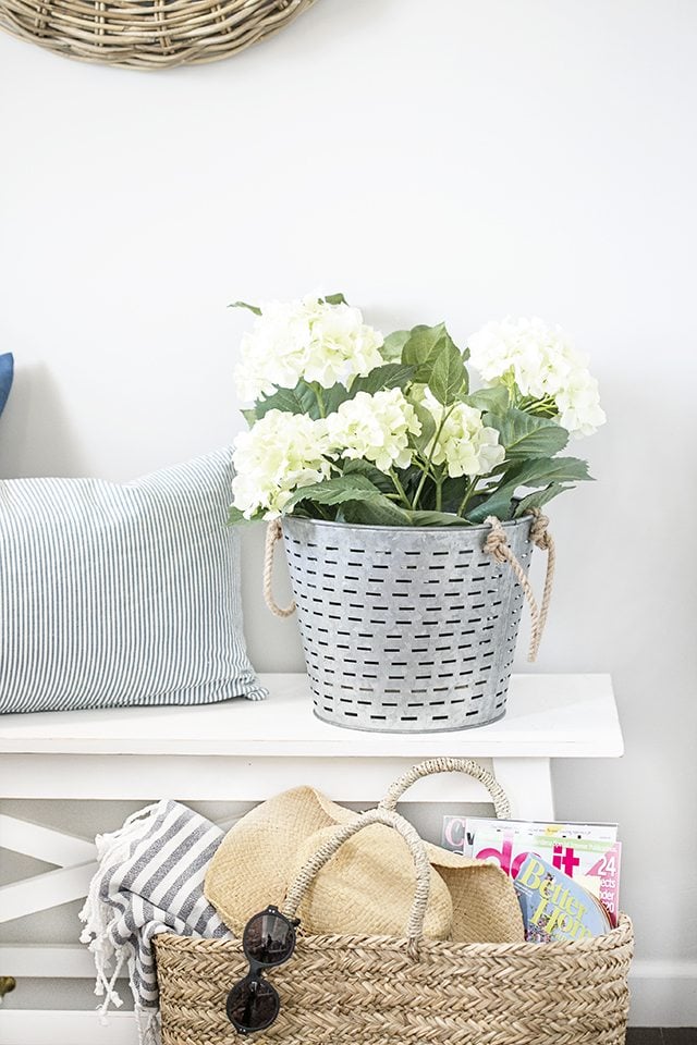 A simple summer entryway with shades of blue and seasonal flowers create a warm and welcoming space. livelaughrowe.com