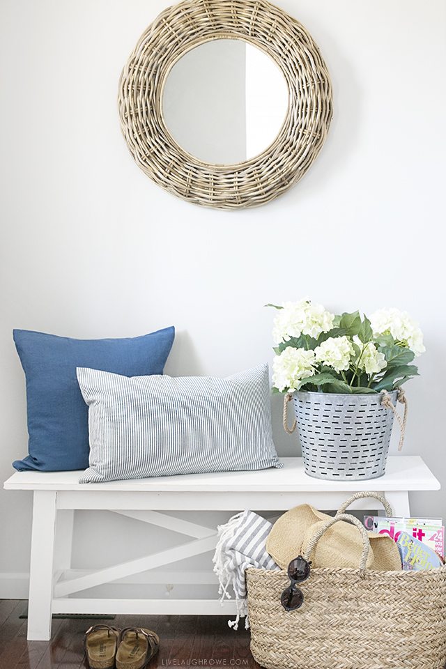 A simple summer entryway with shades of blue and seasonal flowers create a warm and welcoming space. livelaughrowe.com