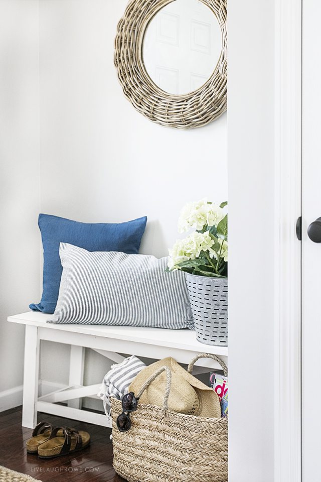 A simple summer entryway with shades of blue and seasonal flowers create a warm and welcoming space. livelaughrowe.com