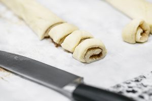 Rolling the dough and cutting the mini cinnamon buns.