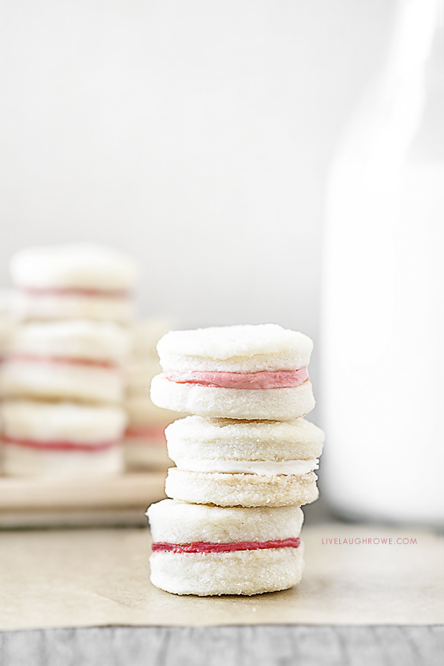 Meet your new favorite cookie! This Cream Wafer Cookie Recipe is packed with sweet, buttery crunchy goodness. Make the frosting with different colors for holidays and special events... like these with pink filling for Valentine's Day! Recipe at livelaughrowe.com