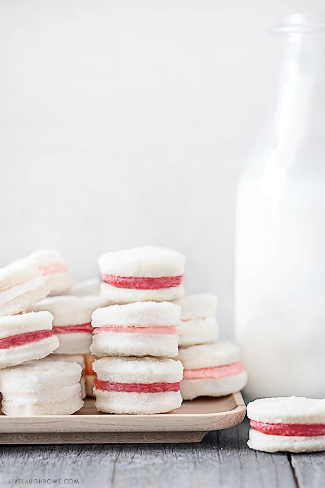 Meet your new favorite cookie! This Cream Wafer Cookie Recipe is packed with sweet, buttery crunchy goodness. Make the frosting with different colors for holidays and special events... like these with pink and red filling for the perfect Valentine's Day dessert! Recipe at livelaughrowe.com