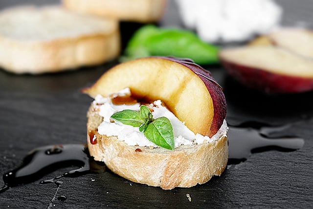 An appetizer that will impress the palates of your friends. Peach Crostini with Goat Cheese and other flavorful ingredients. Simple and delicious! Recipe at livelaughrowe.com