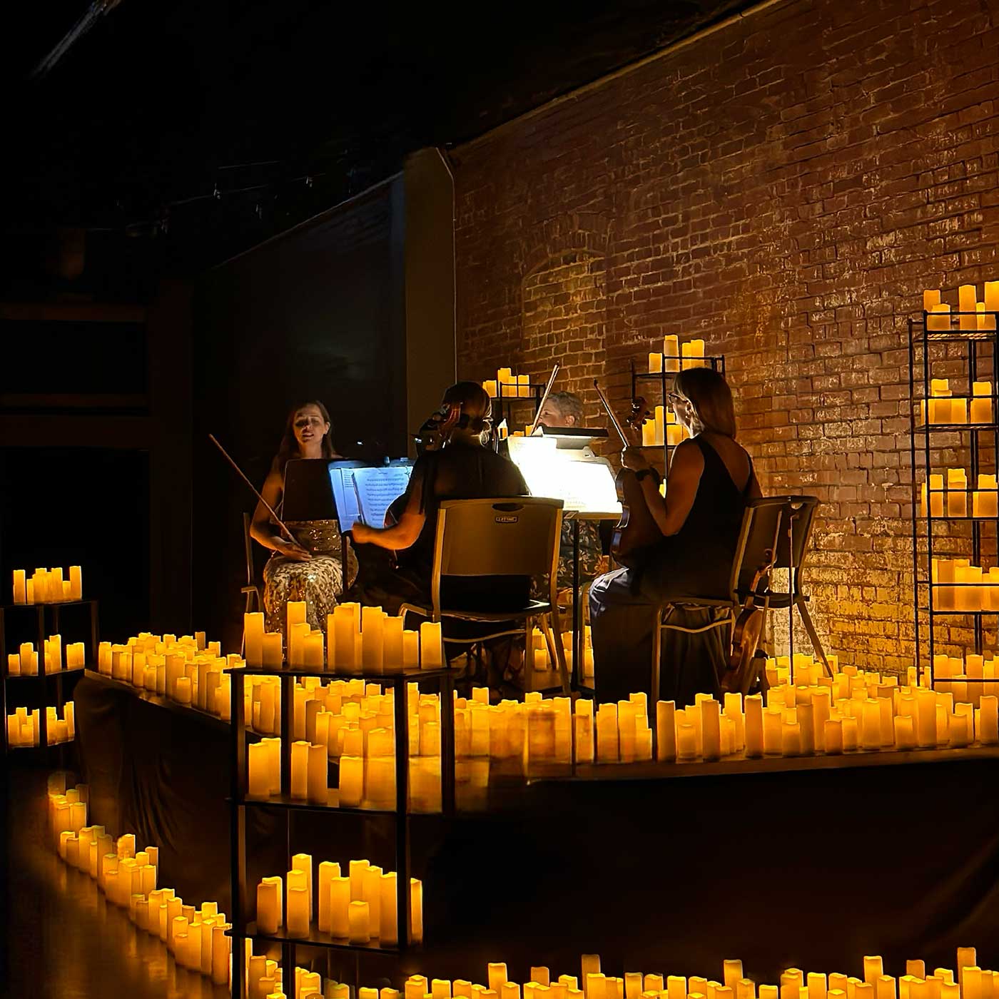 Picture of string quartet playing amongst candlelight