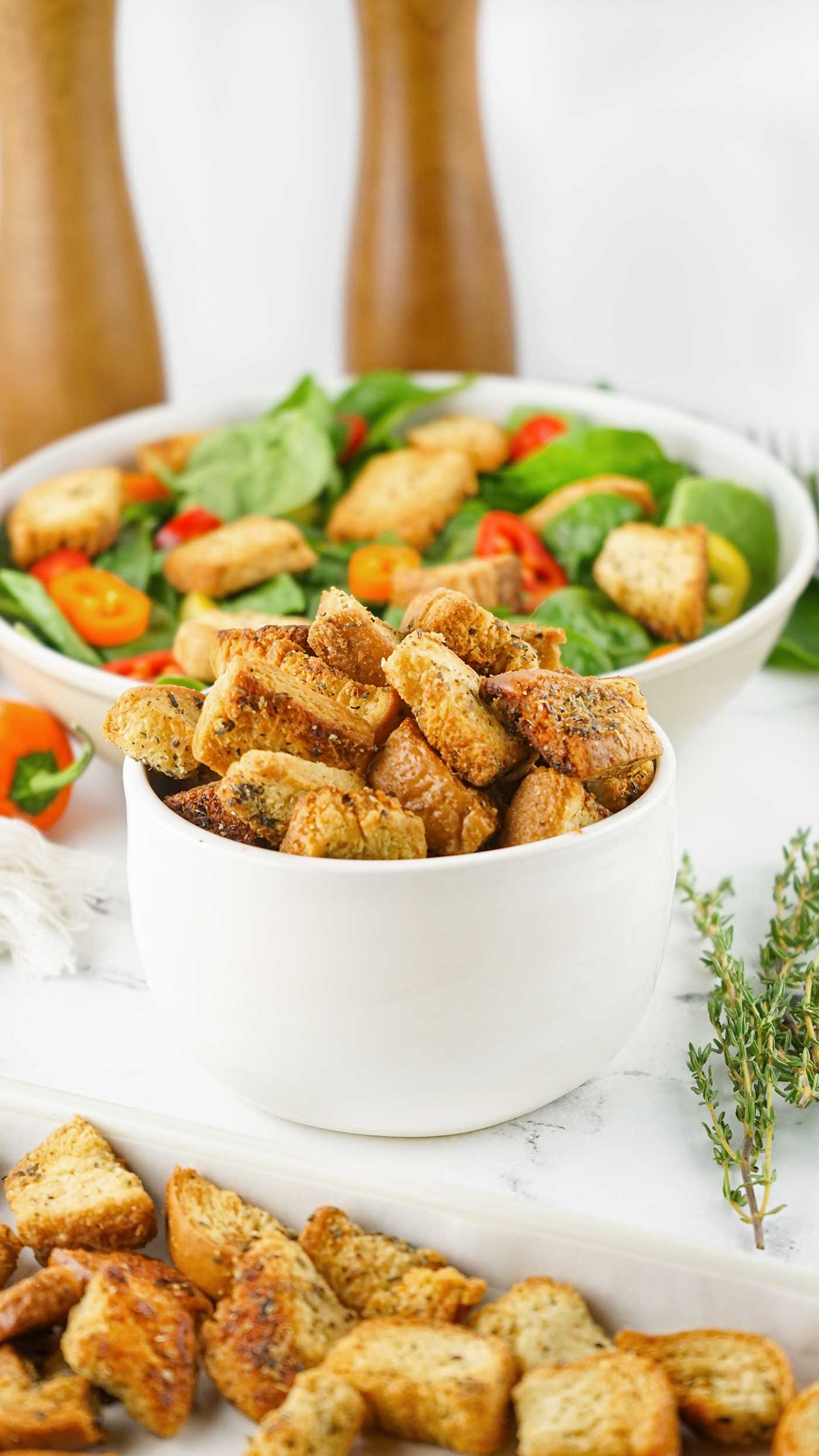 Homemade Croutons in a bowl with a salad in the background