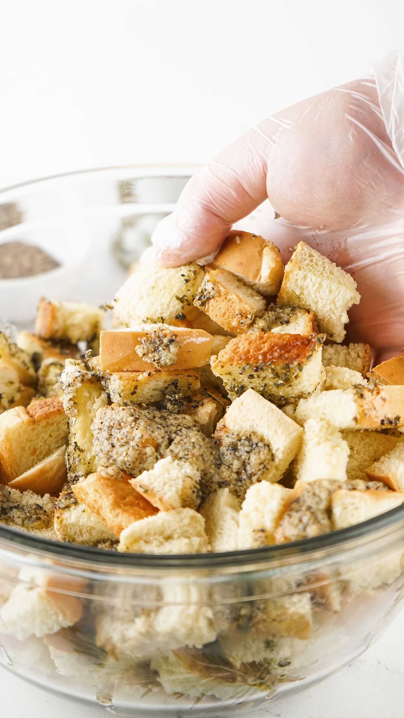 mixing herbs and butter with cubed bread