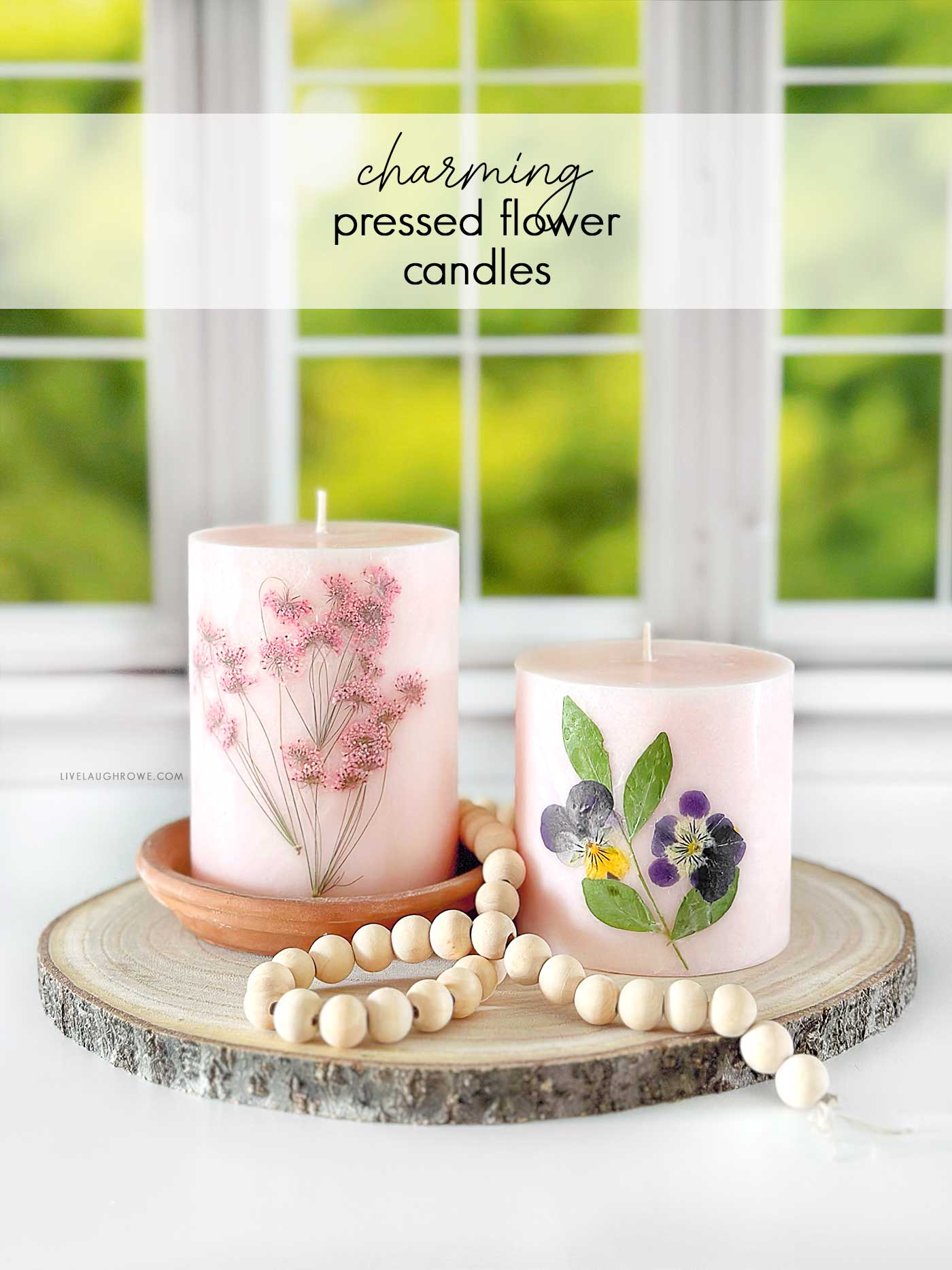 pink candles with pressed flowers styled on slice of wood