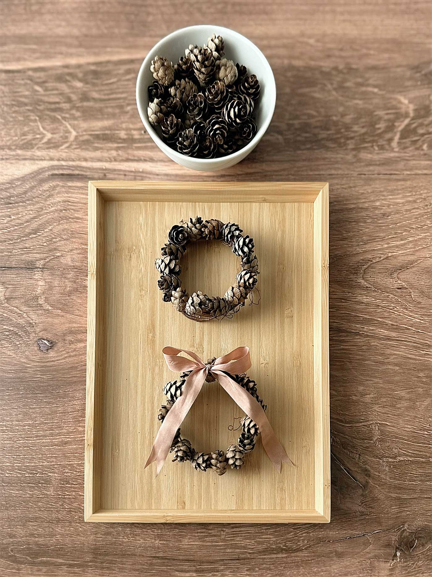 putting a bow on the pinecone wreath