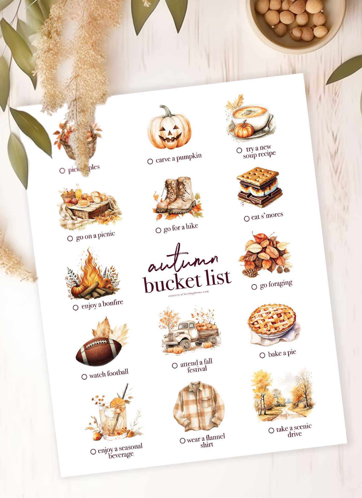 autumn bucket list printable on wood with fall greenery