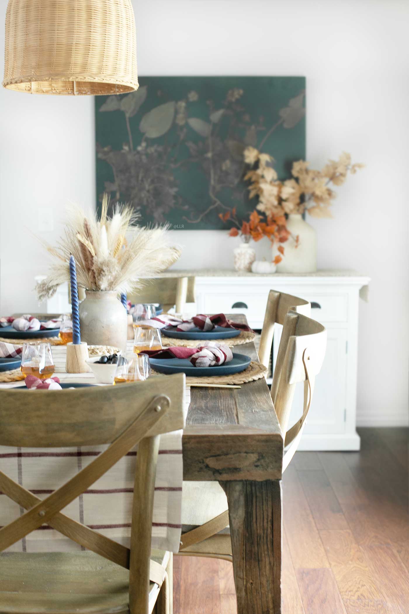 Lovely Tablescape for Fall with a buffet table in the background, decorated with leaves