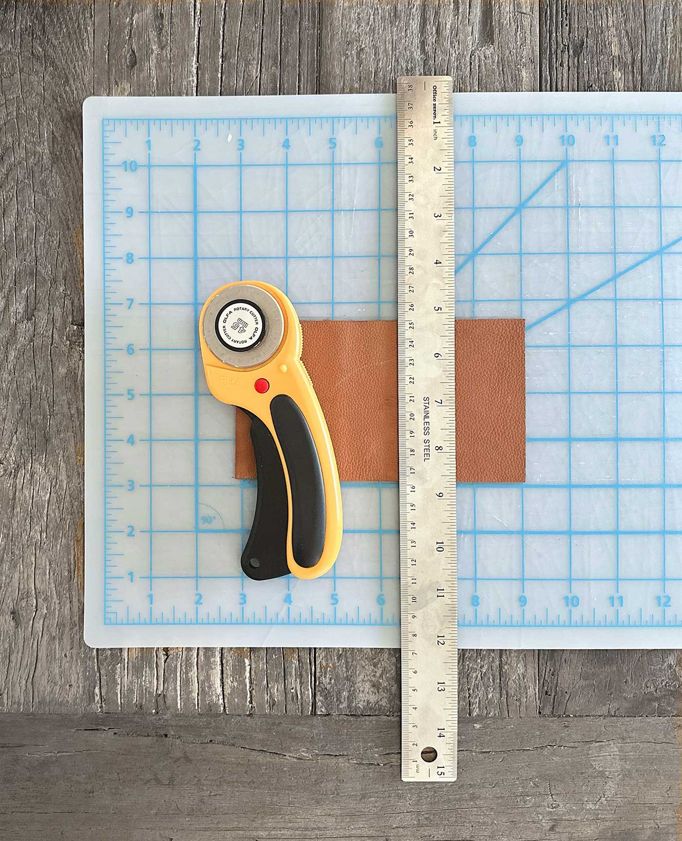 cutting mat with a ruler to be used as a straight edge, leather and a rotary cutter