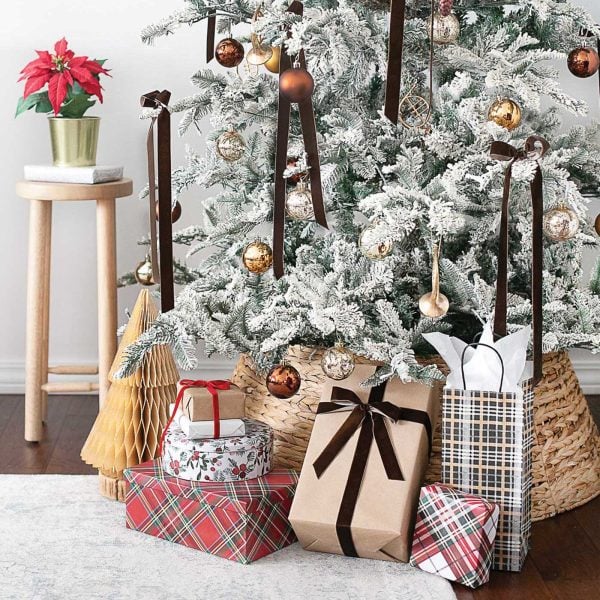 decorated flock tree with a wicker collar and gifts around it