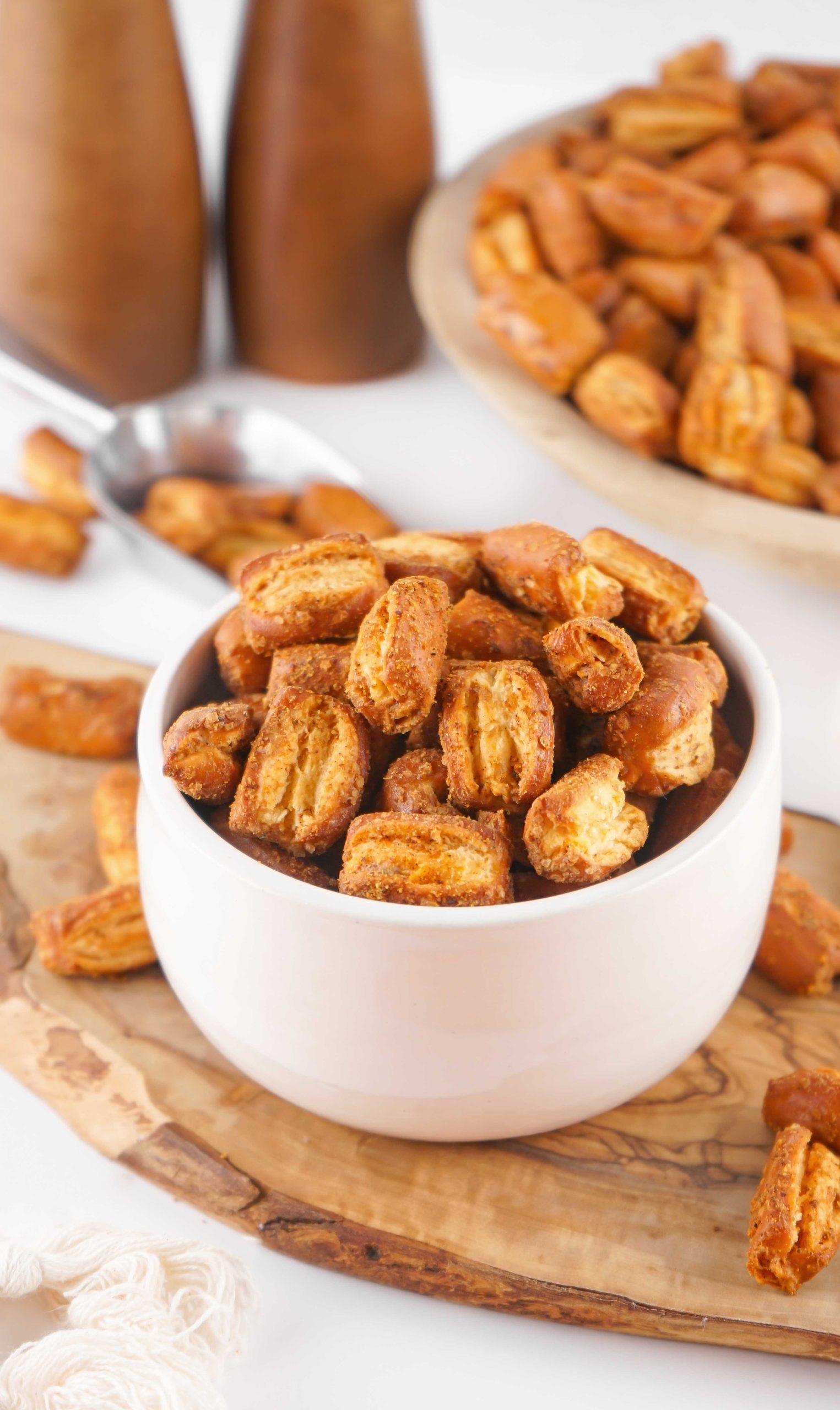 small white bowl with sourdough pretzels on a wooden trivet with salt and pepper shakers in the background