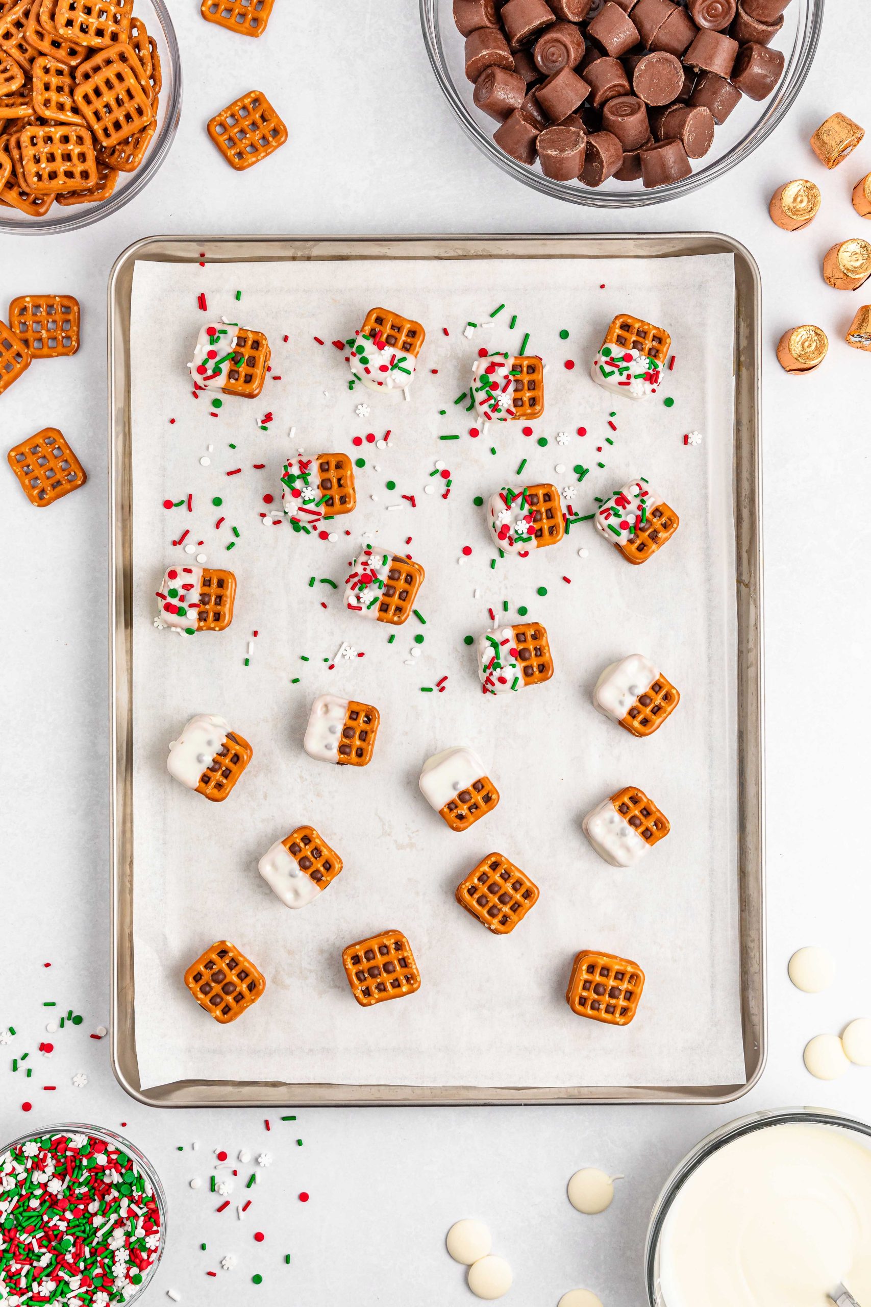 sprinkles being placed on rolo pretzel sandwiches