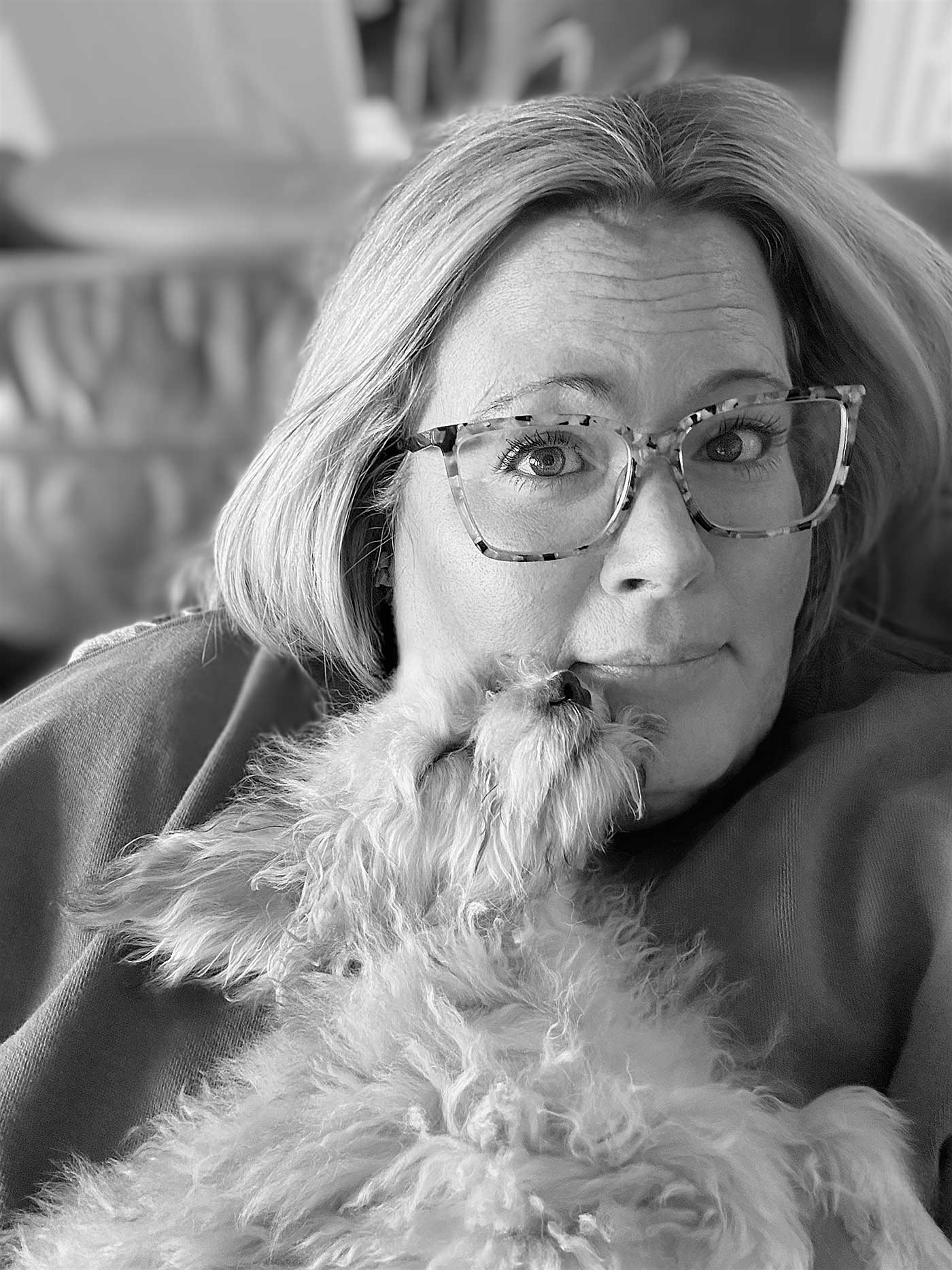 black and white photo of a woman holding a havapoo puppy