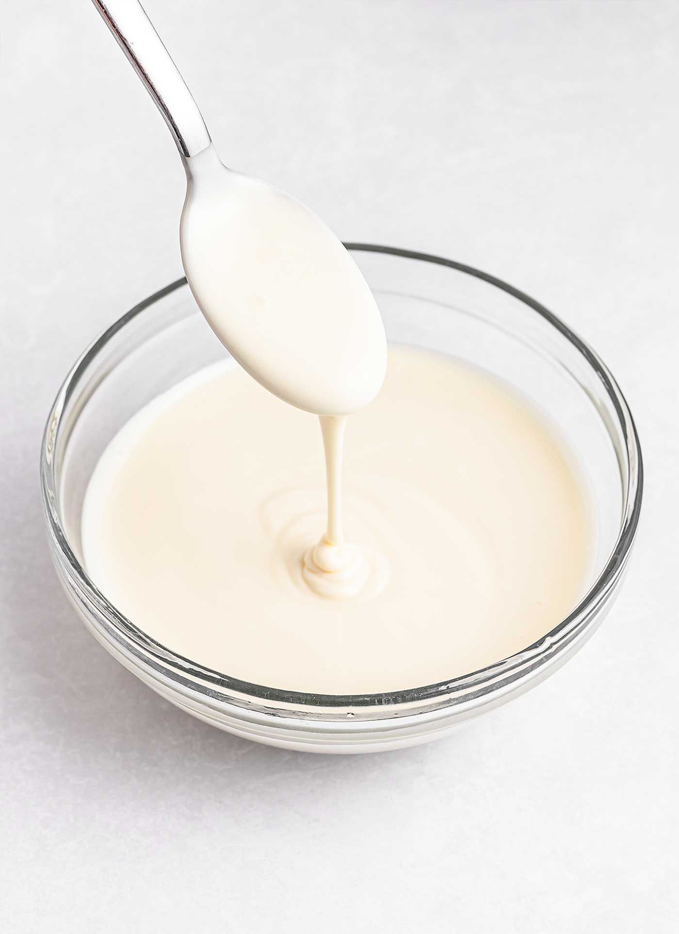 white melted chocolate in a bowl with a spoon