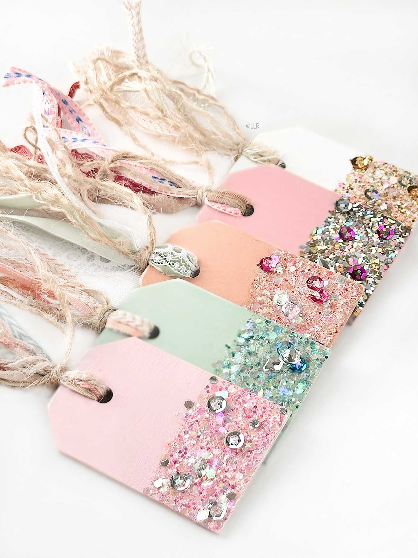 five gift tags dipped in glitter, lots of sparkle and attached ribbon