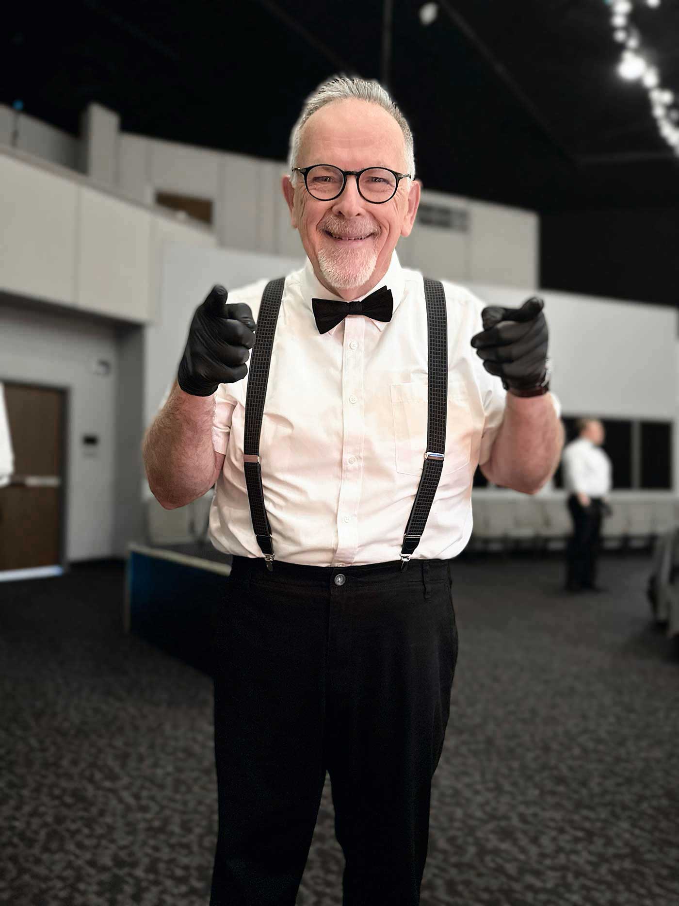 senior man in a black and white serving outfit