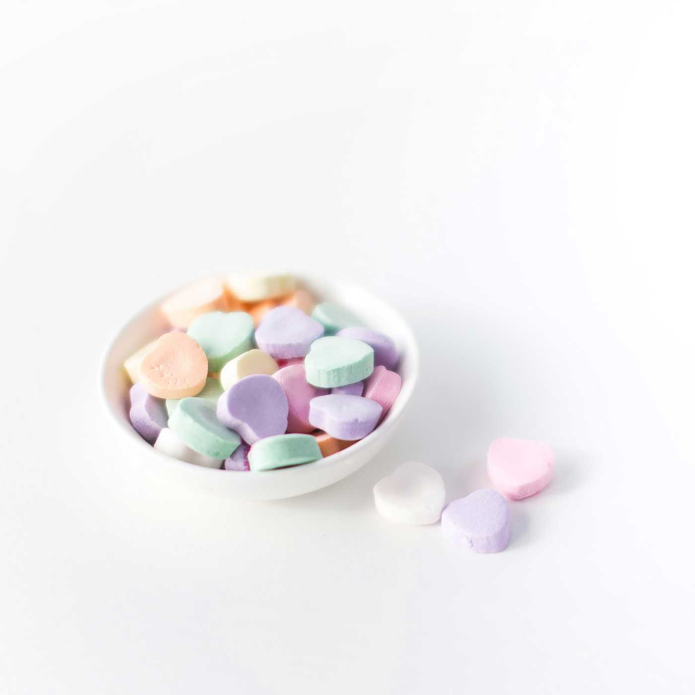 candy hearts in a little white bowl