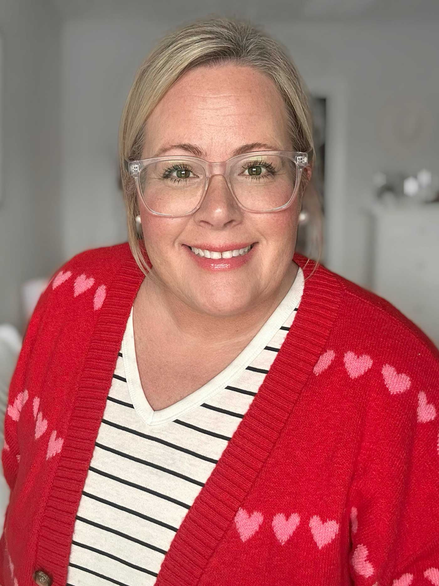 middle aged woman in a red valentines sweater with a striped t-shirt