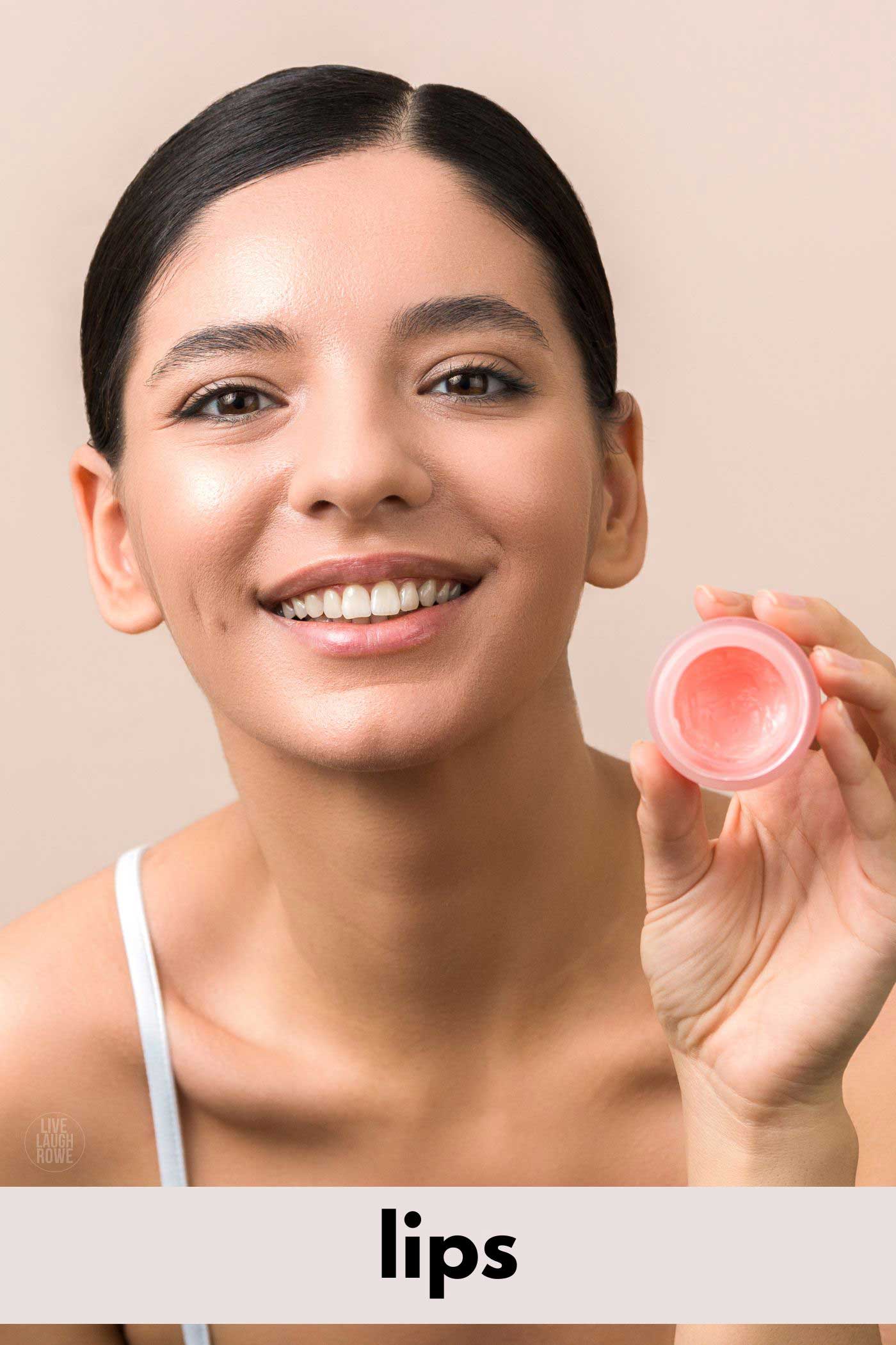 woman smiling, holding a lip gloss pot