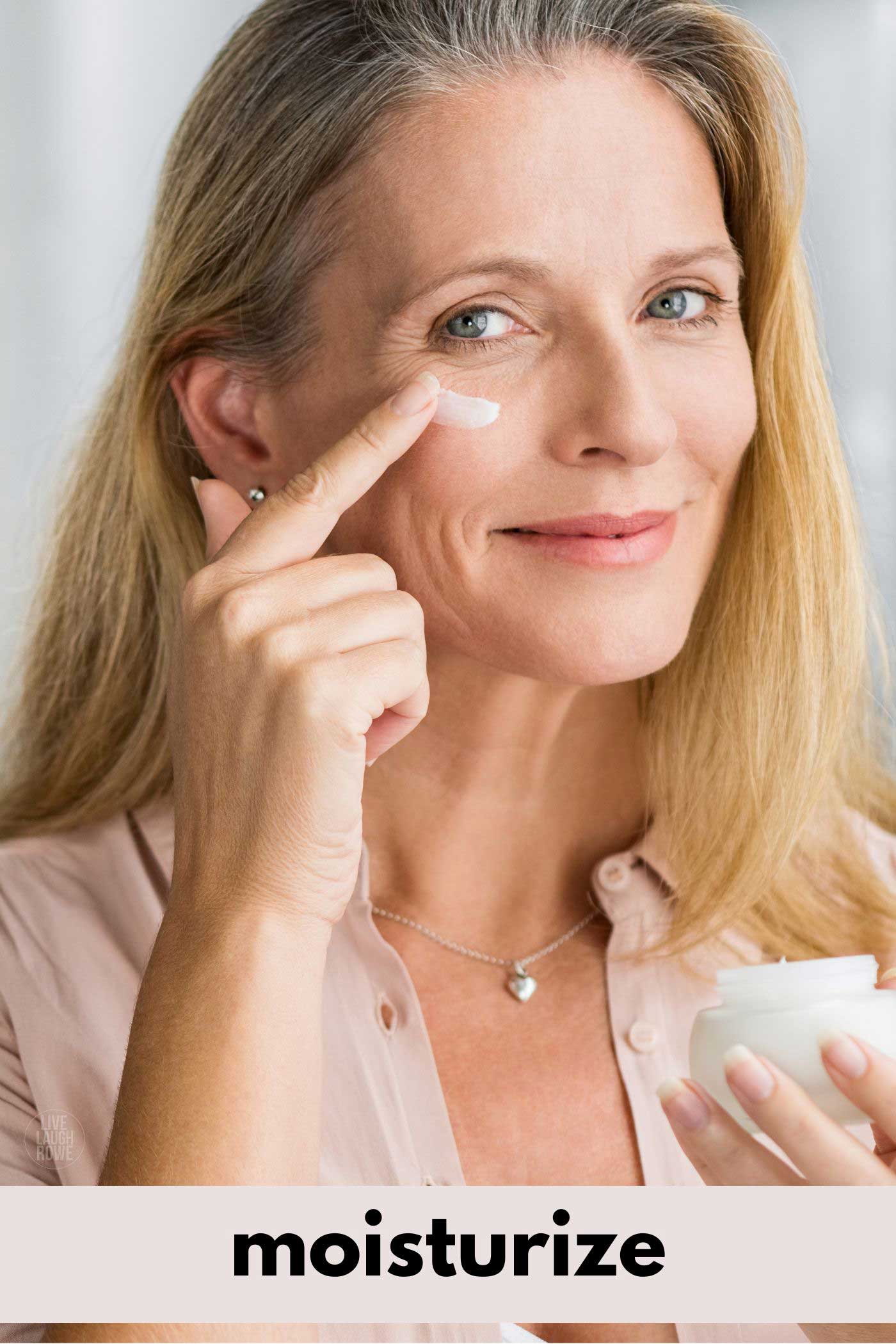 a middle aged woman applying a moisturizer to her face