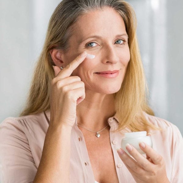 woman applying cream to face