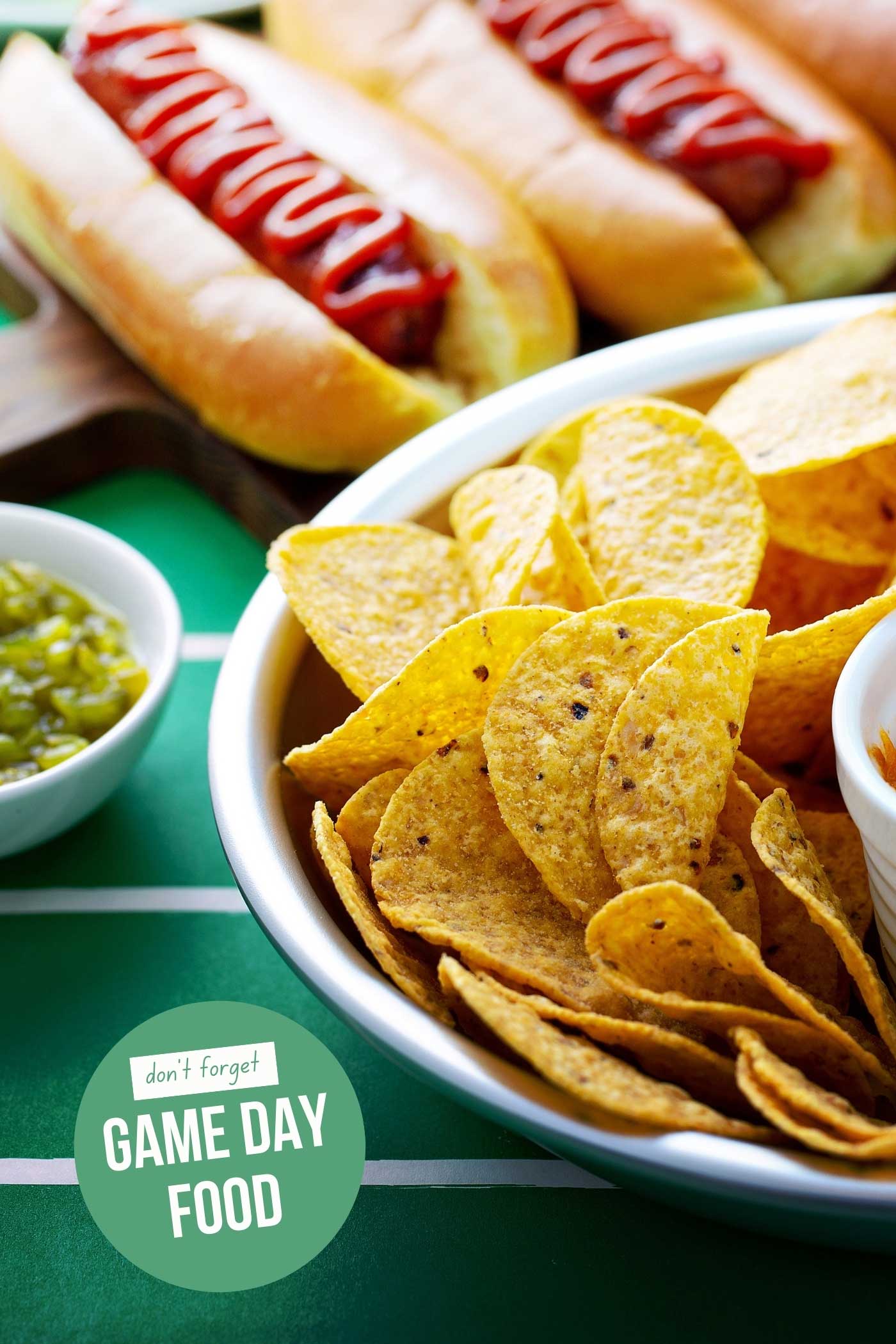 football game time food and snacks. chips and salsa with hot dogs.