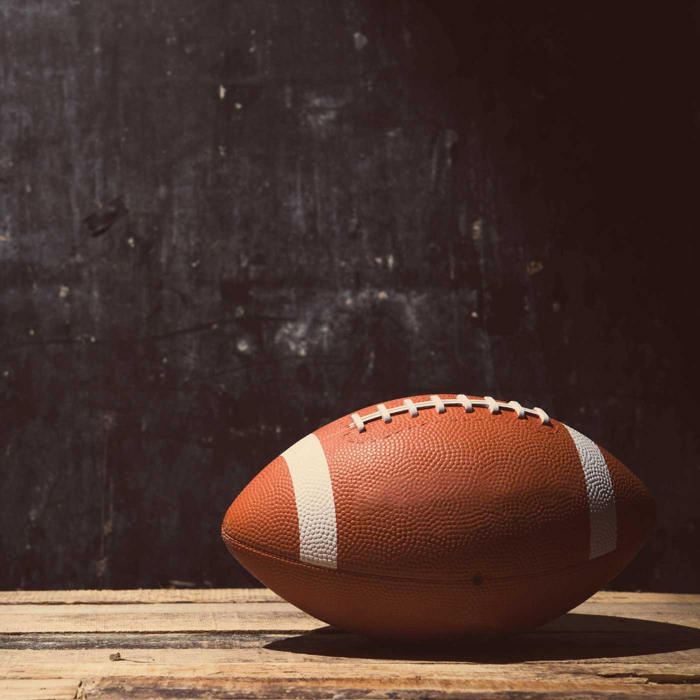 football sitting on wooden table with black chalkboard behind it