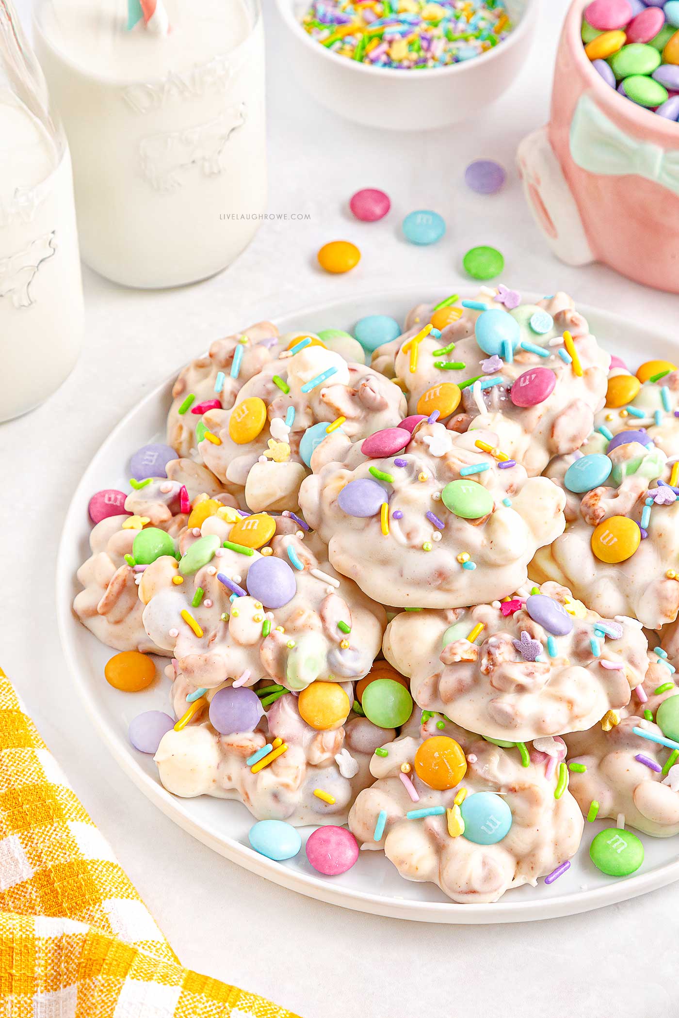 a white plate of Easter Crockpot Candy with milk, an Easter mug and a napkin placed around it