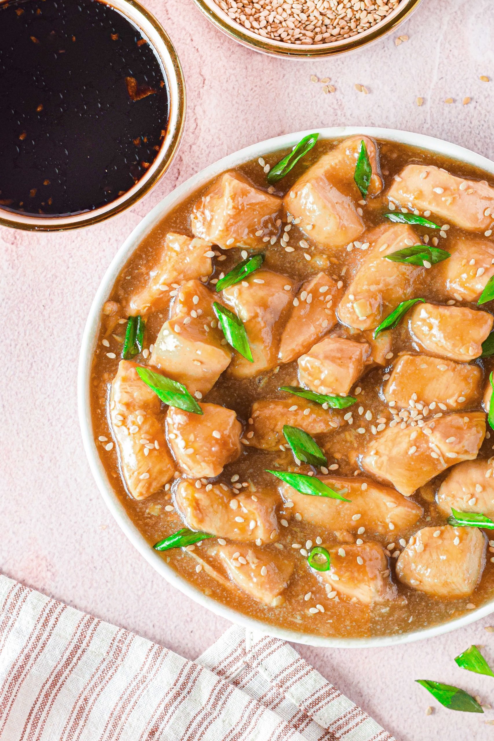 plate of chicken with a gravy and green onions