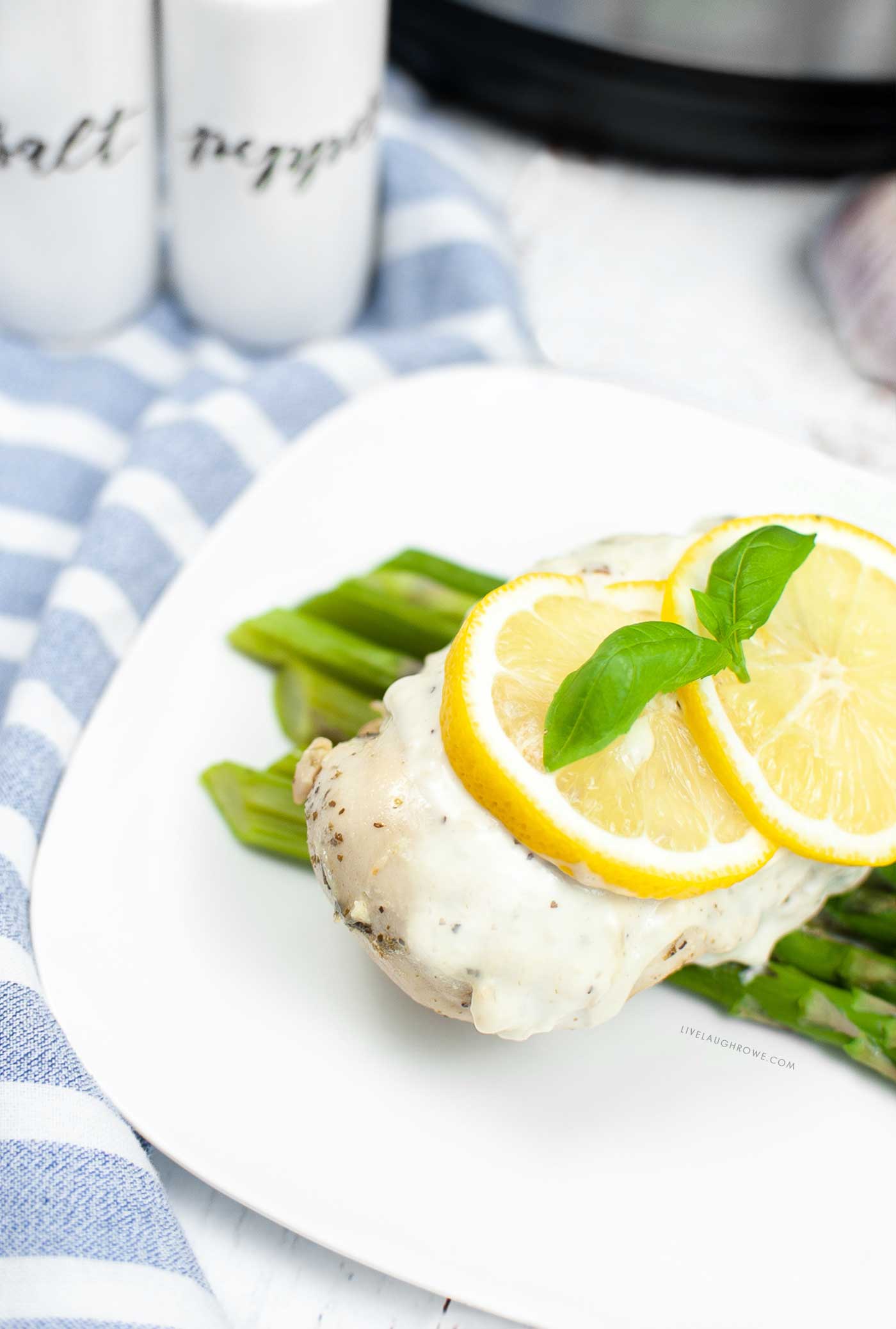 creamy lemon chicken plated with salt and pepper shakers and an instant pot in the background