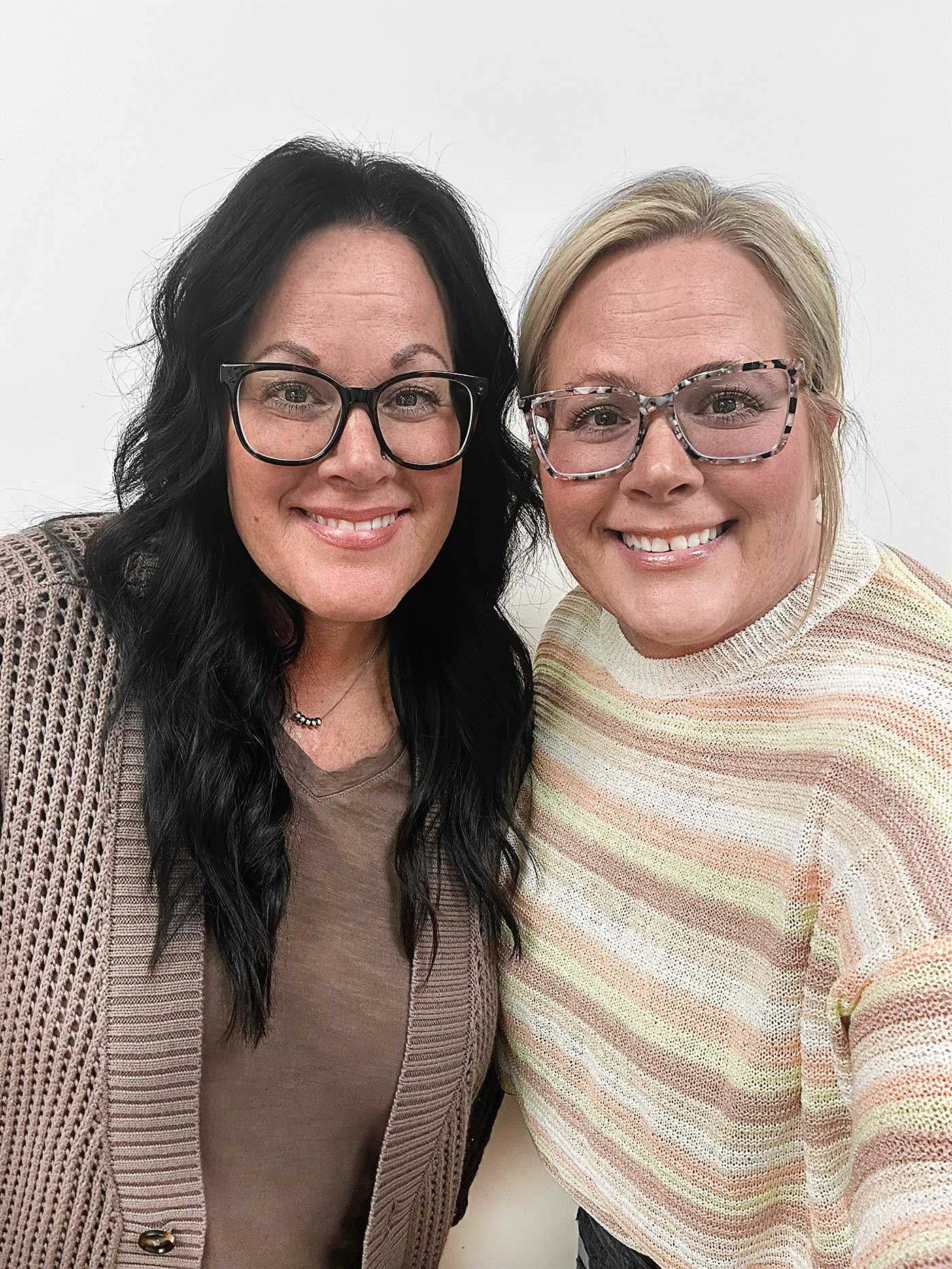 middle aged twins, one with dark hair, the other a blonde