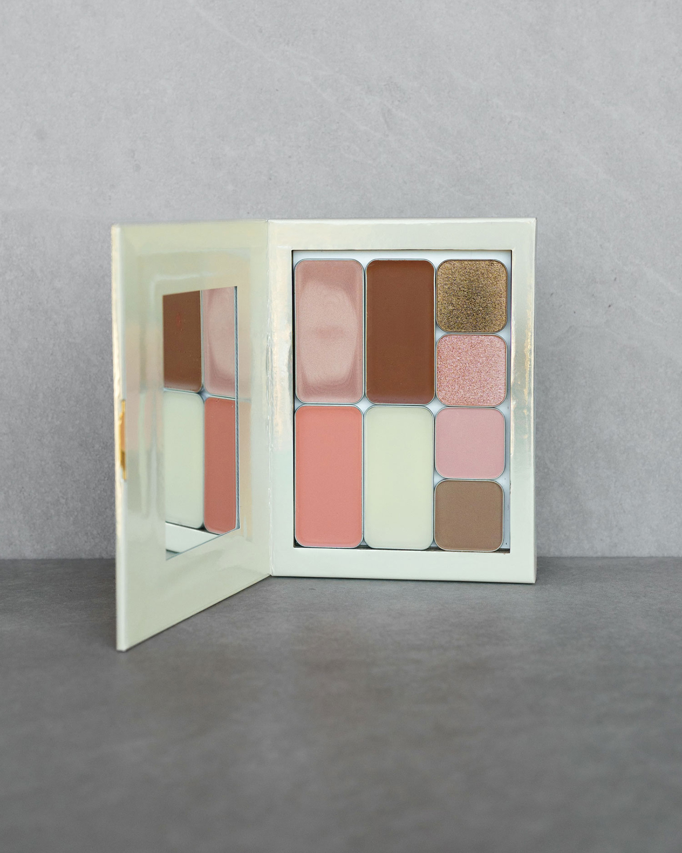 a palette of makeup on its side featuring eight tins of various makeup
