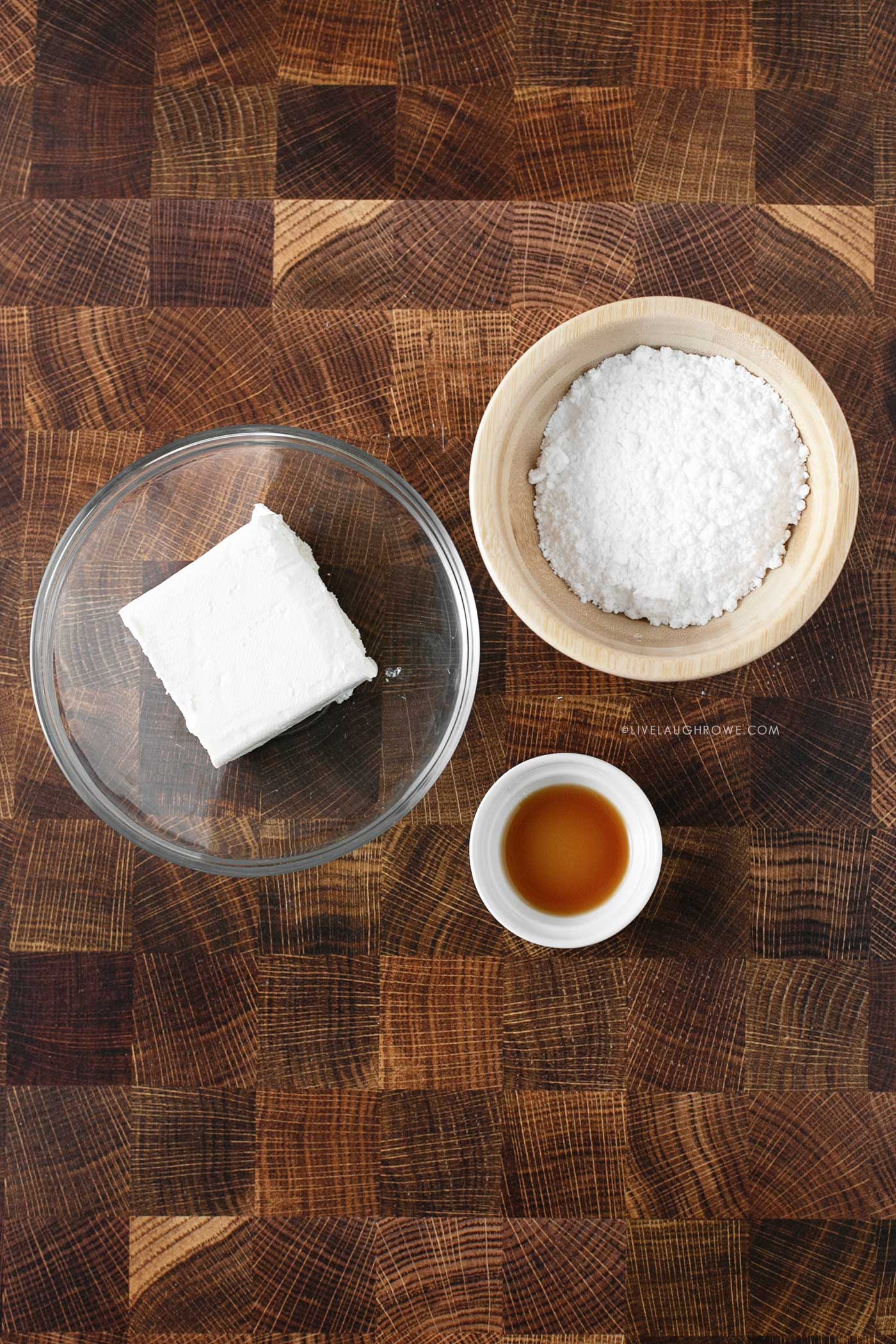 three prep bowls with ingredients for cream cheese frosting: Cream Cheese, Confectioner's Sugar and Vanilla Extract