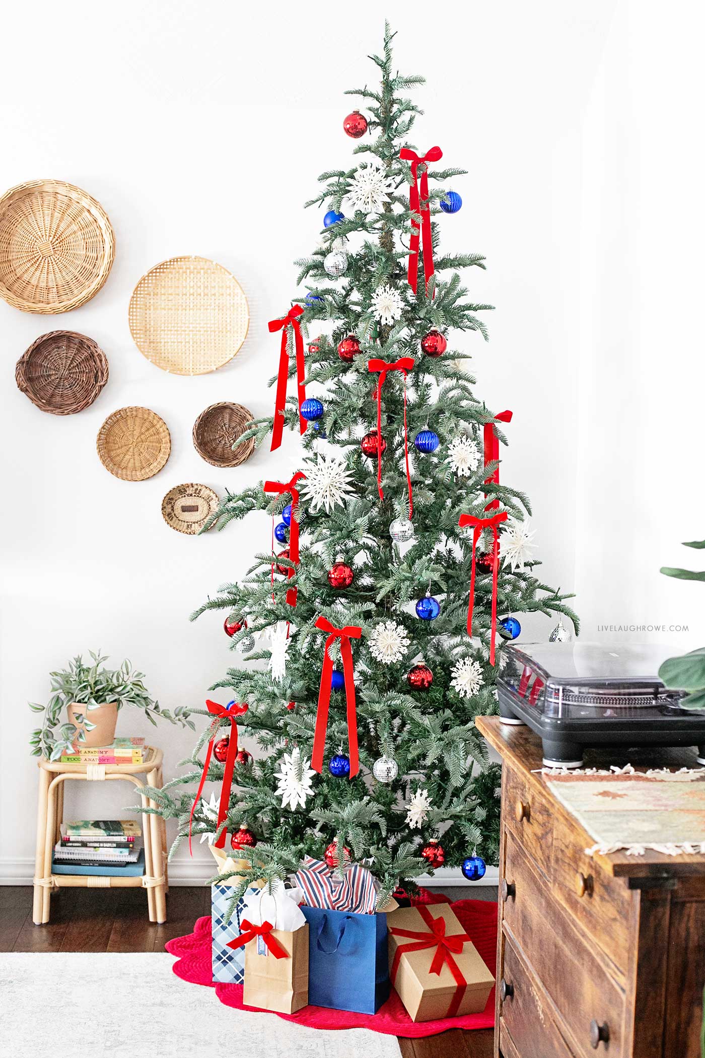 Fully decorated tree with a red tree skirt and bold July 4th theme, featuring the King of Christmas 8-foot Noble Fir unflocked tree