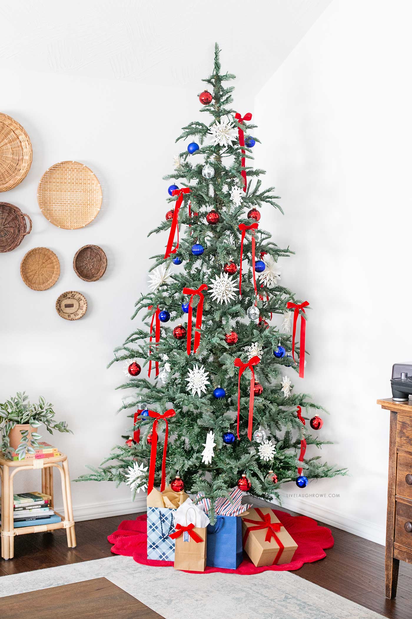 Red velvet bows, blue and silver ornaments, and oversized white snowflakes for a festive, summer-ready holiday look.
