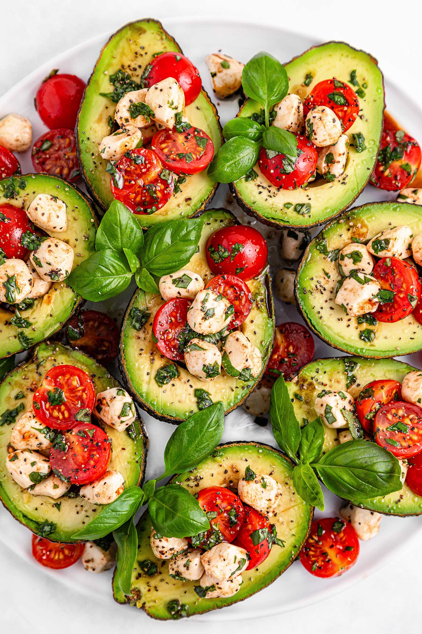 plated caprese stuffed avocados with basil for garnish