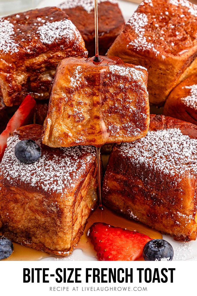 Plate of bite-sized Hawaiian Roll French Toast topped with fresh berries and honey drizzle.
